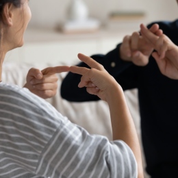 Närbild av händerna på par som talar teckenspråk. Foto: Mostphotos